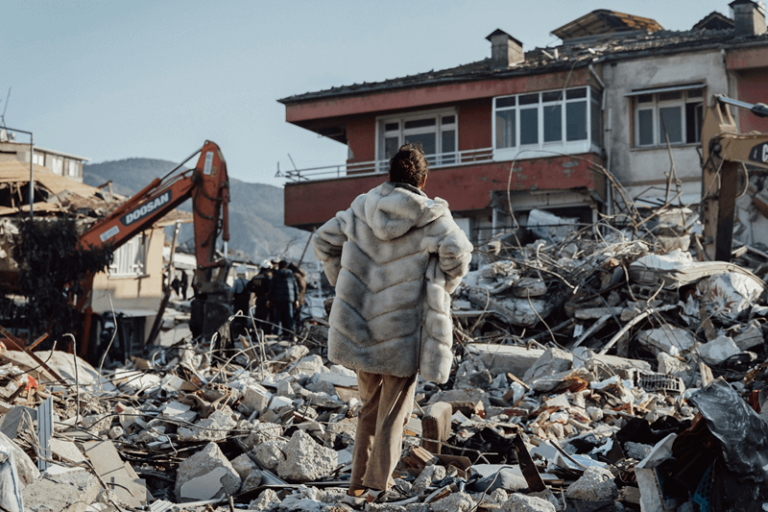 Persona osserva macerie dopo un terremoto.